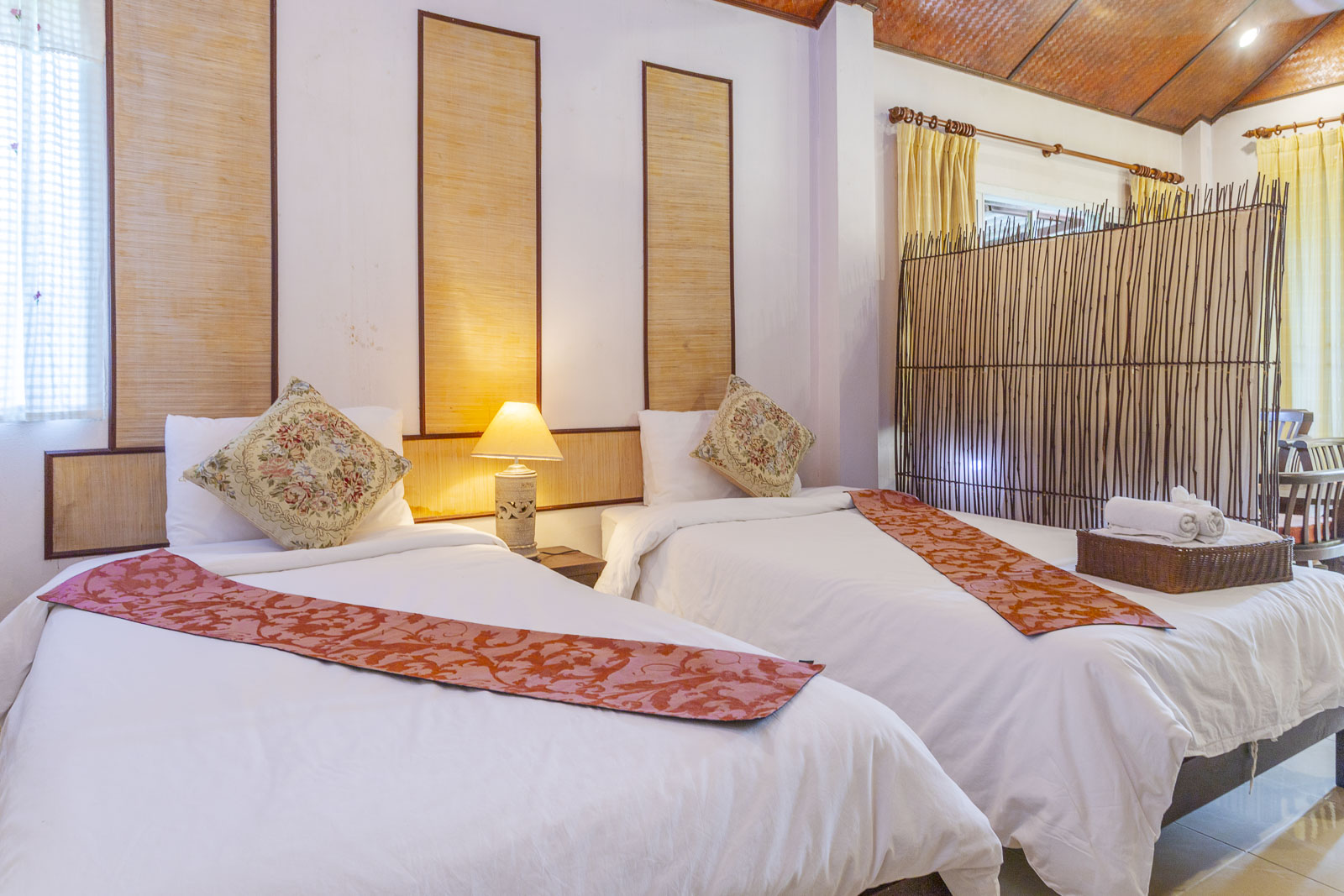 Twin beds with Thai silk runners in a bungalow room